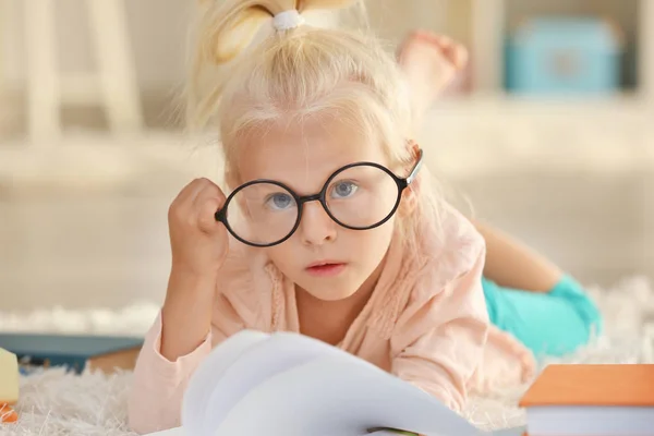 Menina pequena em óculos com livros — Fotografia de Stock