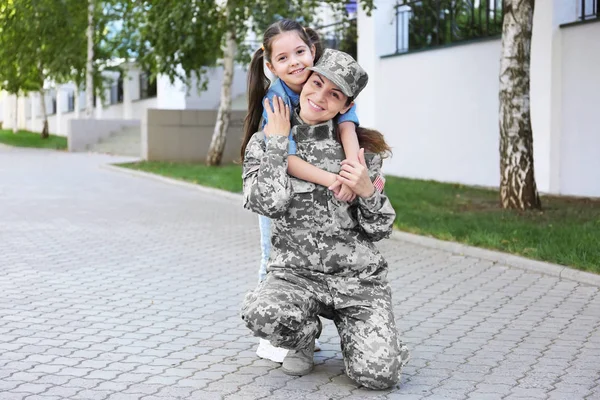 Mãe de uniforme do exército e filha na rua — Fotografia de Stock