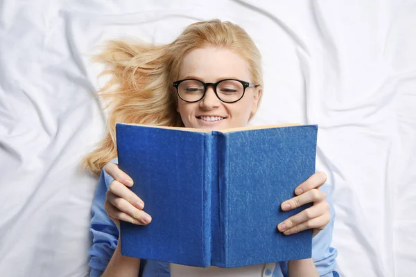 Hermosa chica leyendo libro en la cama —  Fotos de Stock