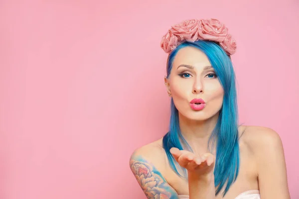 Hermosa mujer joven con pelo de color elegante y tatuaje sobre fondo rosa — Foto de Stock