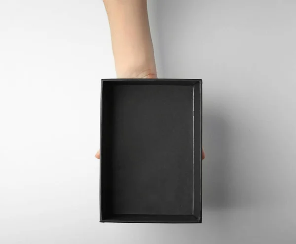 Weibliche Hand mit schwarzer offener Schachtel — Stockfoto