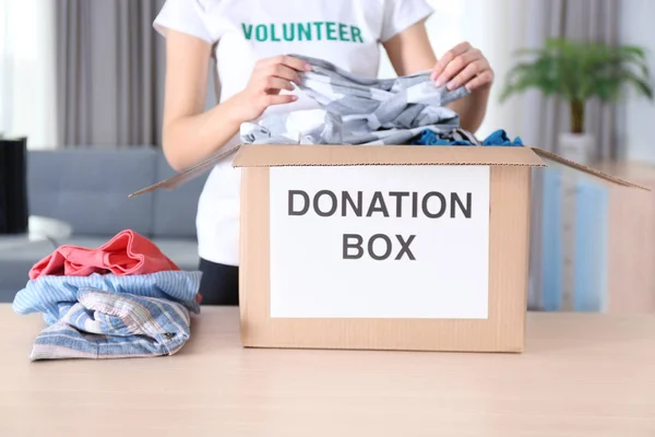 Voluntário colocando roupas em caixa de doação — Fotografia de Stock