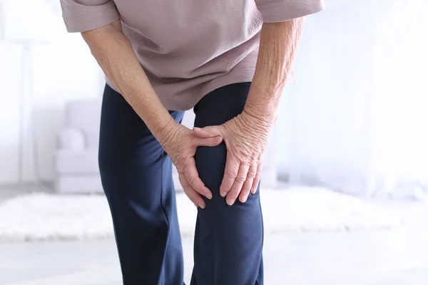 Starší žena trpí bolestí v koleně — Stock fotografie