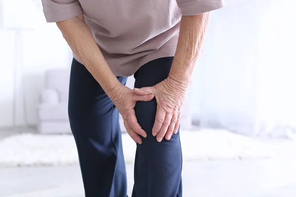 Elderly woman suffering from pain in knee — Stock Photo, Image