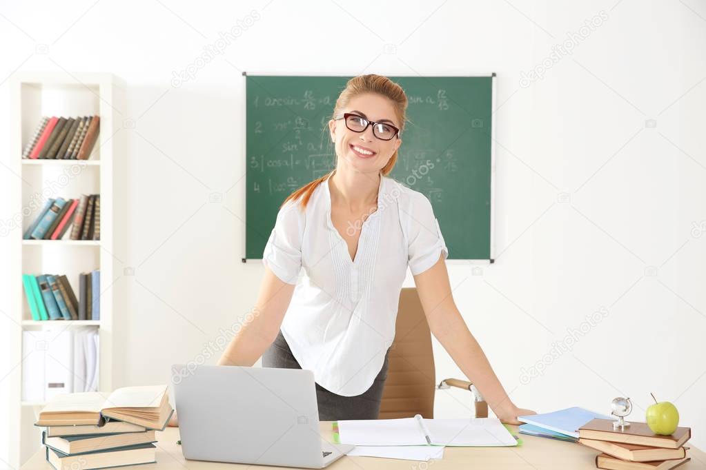 Young teacher at desk  