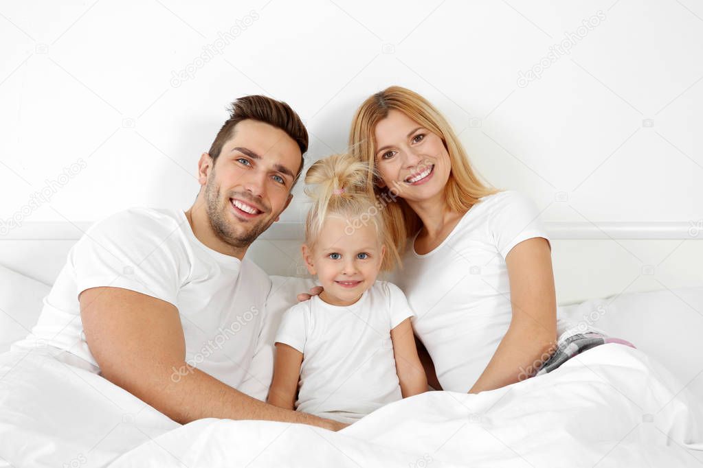 happy family lying in bed 