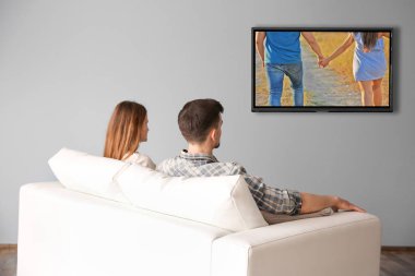 Evde televizyon izlerken aile. Boş zaman ve eğlence kavramı.