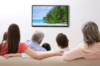 Evde televizyon izlerken aile. Boş zaman ve eğlence kavramı.