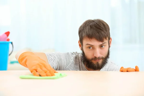 Hombre limpiando muebles con servilleta — Foto de Stock