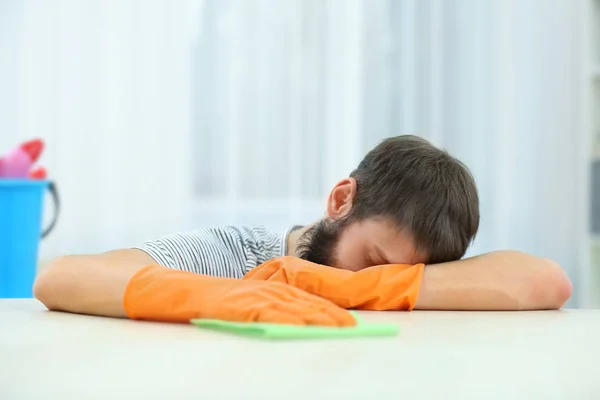 Człowiek zmęczony wycieranie mebli — Zdjęcie stockowe