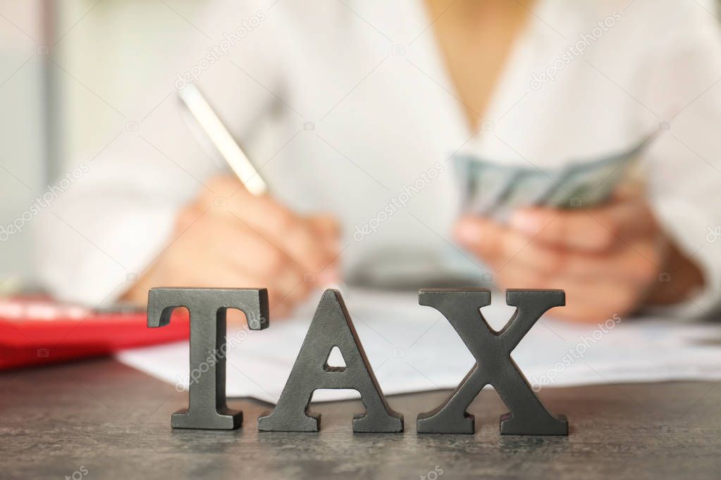 Word TAX on wooden table