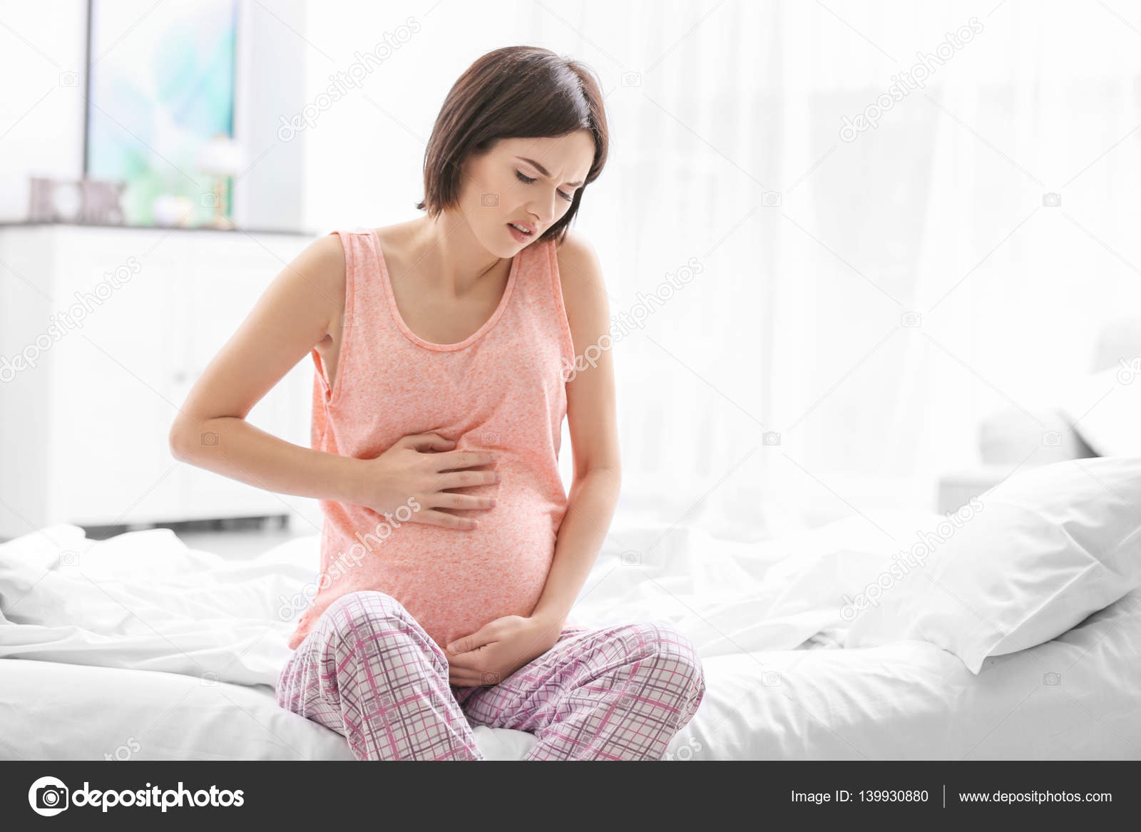Схватки утром. У беременной болит живот. Беременные женщины. Молодые беременные.