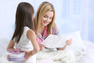 Sevimli küçük kız annesinin arkasından mevcut gizleme. Anneler günü kavramı