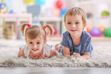 Şirin komik çocuk evde halı üzerinde yalan