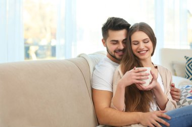 Genç çift kanepede oturuyor.