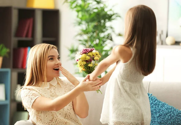 Liten flicka ger bukett vackra blommor till sin mor. Mors dag koncept — Stockfoto