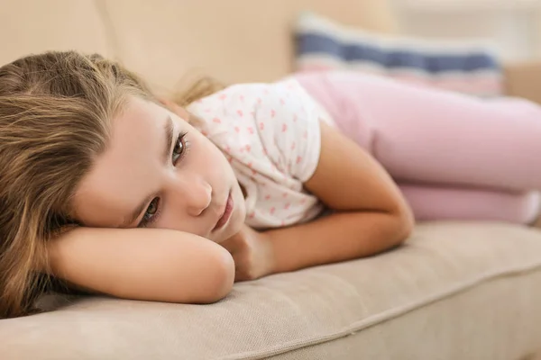 Грустная маленькая девочка лежит на диване, крупным планом — стоковое фото
