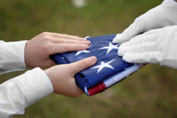 Hands with folded American flag