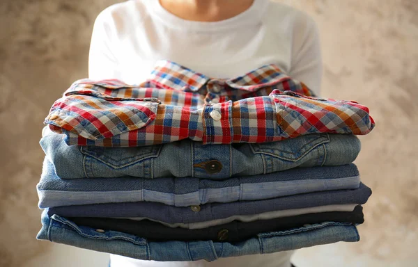 Woman holding clothes in hands — Stock Photo, Image