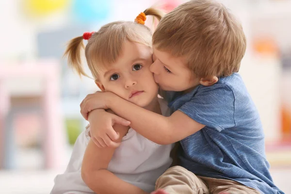 Söt liten pojke kramar syster hemma — Stockfoto