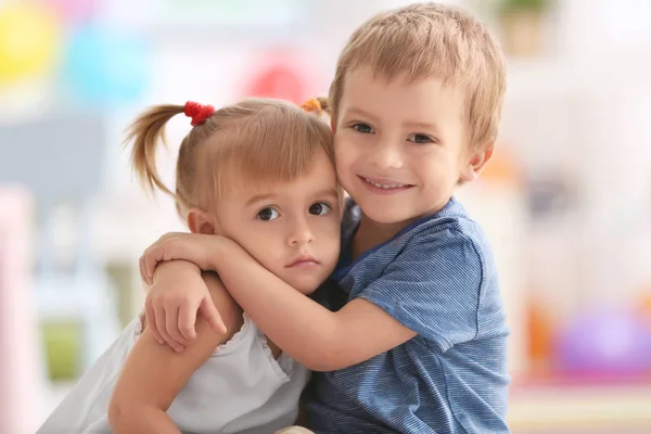 Cute little boy hugging sister at home — Stock Photo, Image