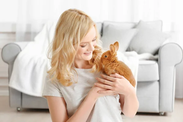 Menina bonita com coelho pequeno em casa — Fotografia de Stock