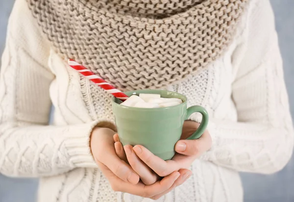 Woman holding candy cane and cup — Stock Photo, Image