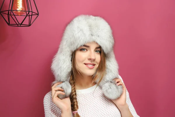 Beautiful young woman with warm hat on color background — Stock Photo, Image