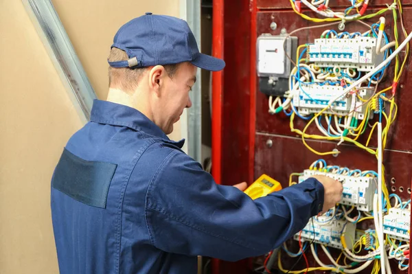 Tensión de medición del electricista en la placa de distribución — Foto de Stock