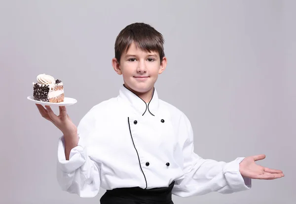 Cute boy in chef uniform on light background — Stock Photo, Image