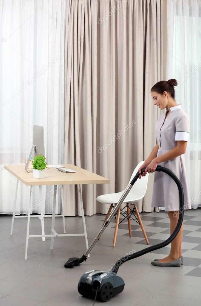 Female chambermaid with vacuum 