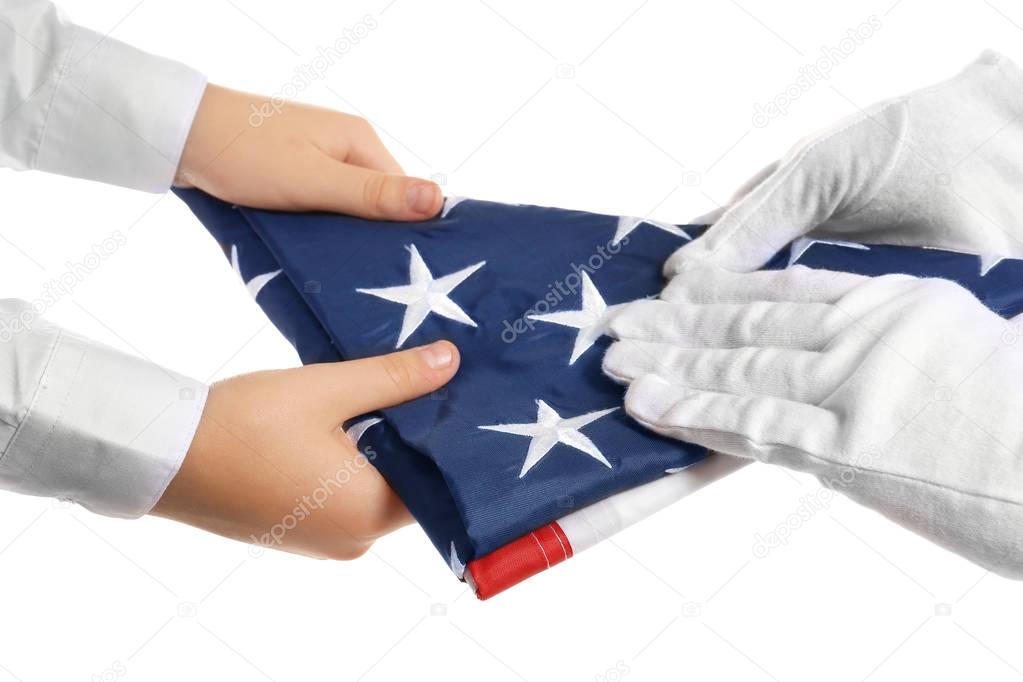 Hands holding folded American flag
