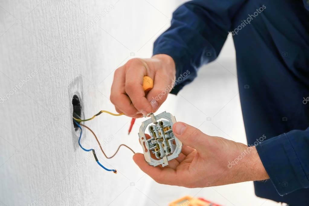 Electrician attaching wires to socket 