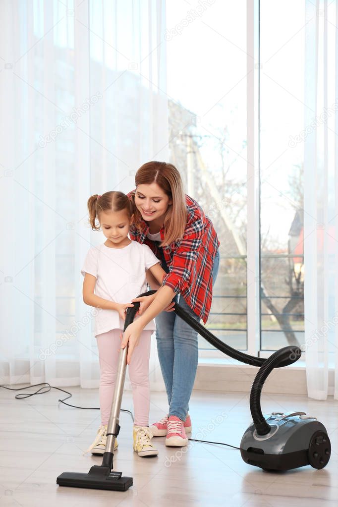 woman and daughter hoovering floor 
