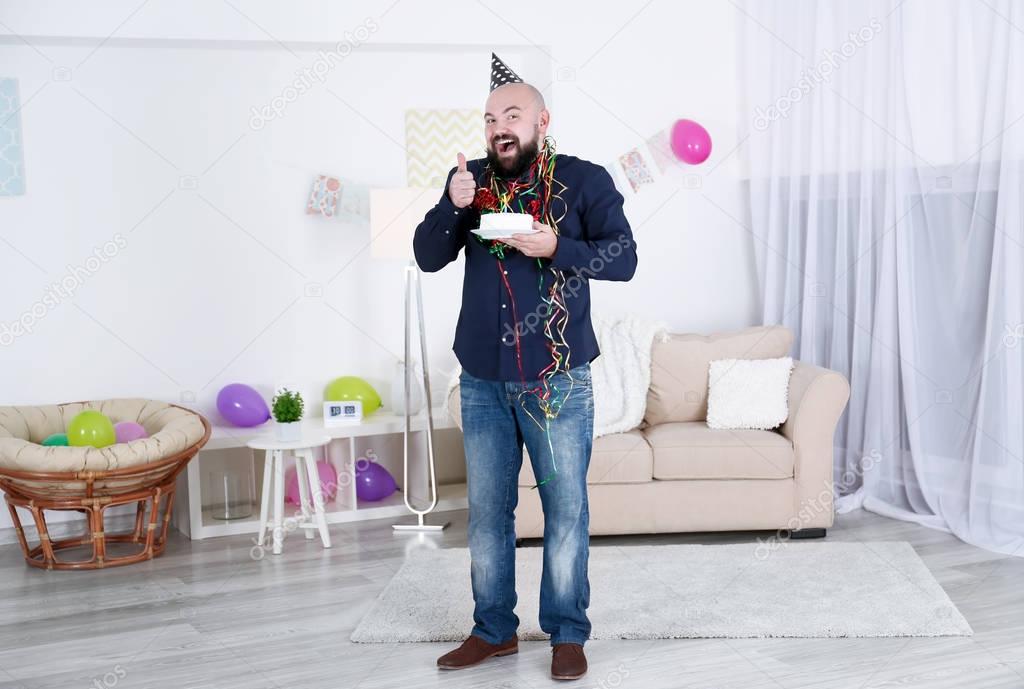 Funny fat man with birthday cake at party