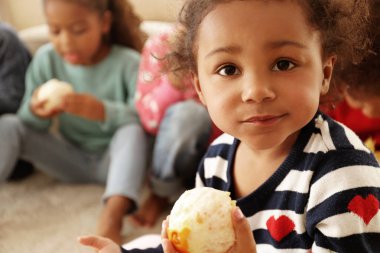 Katta oturan ve portakal yeme şirin Afrikalı kızlar