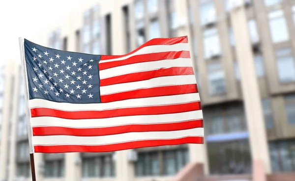 Amerikaanse vlag op de achtergrond wazig gebouw — Stockfoto