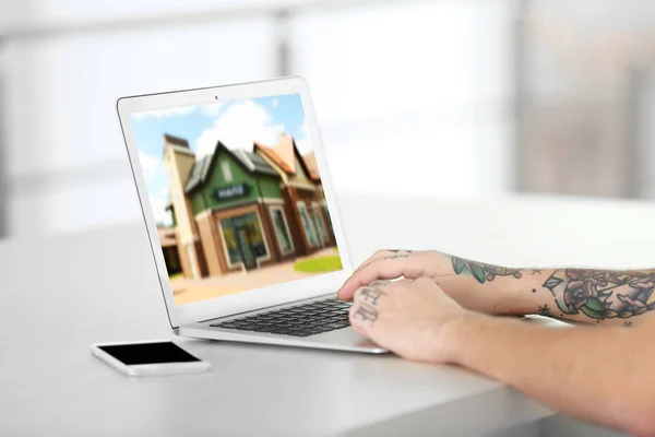 Online nakupování koncept. Muž hledá dům na stránkách trhu nemovitostí — Stock fotografie