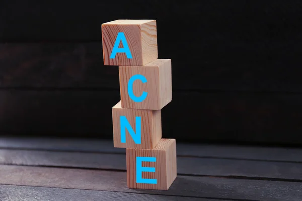 Słowo ACNE drewnianych kostek na stole. Koncepcja pielęgnacji skóry — Zdjęcie stockowe