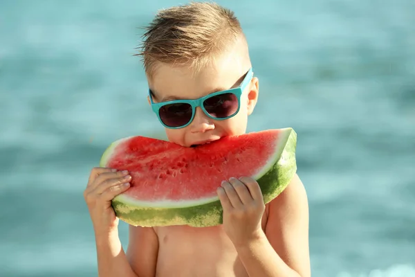 Söt pojke äter vattenmelon på stranden — Stockfoto