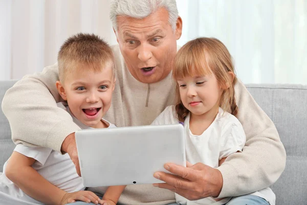 Grootvader met kleinkinderen met behulp van Tablet PC — Stockfoto