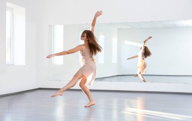 Stüdyoda dans eden güzel genç bir kadın.