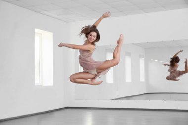 Stüdyoda dans eden güzel genç bir kadın.