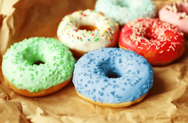 Donuts colorés sur fond de papier émietté — Photo