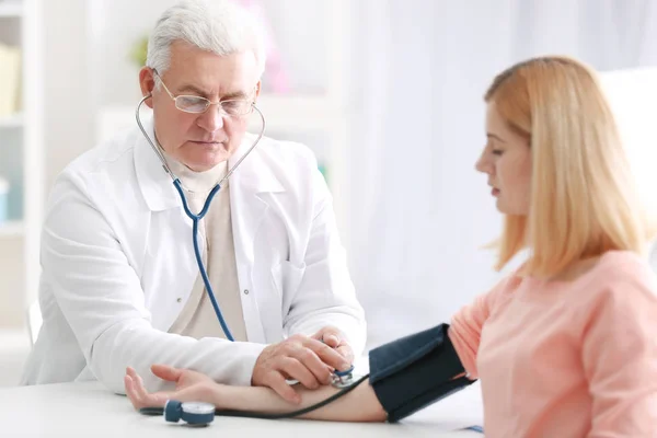 Médico midiendo la presión arterial del paciente — Foto de Stock