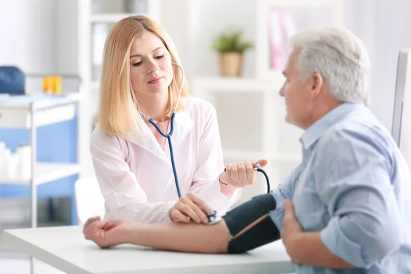 Médico midiendo la presión arterial del paciente — Foto de Stock