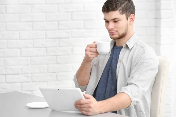 Handsome young man drinking coffee at home — Stock Photo, Image