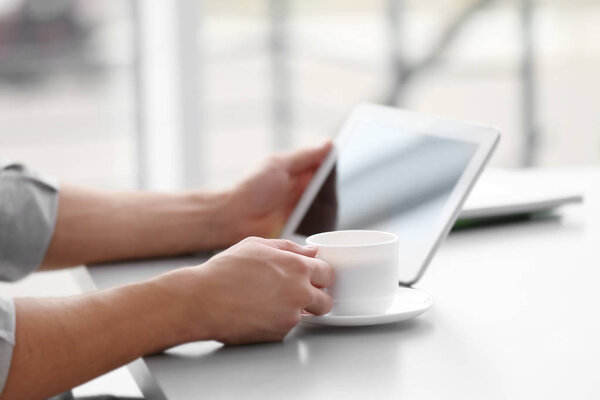  man with tablet drinking coffee