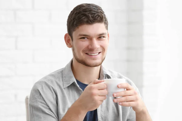 Knappe jongeman die thuis koffie drinkt — Stockfoto