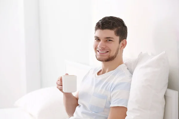 Przystojny młodzieniec pijący kawę w domu. — Zdjęcie stockowe